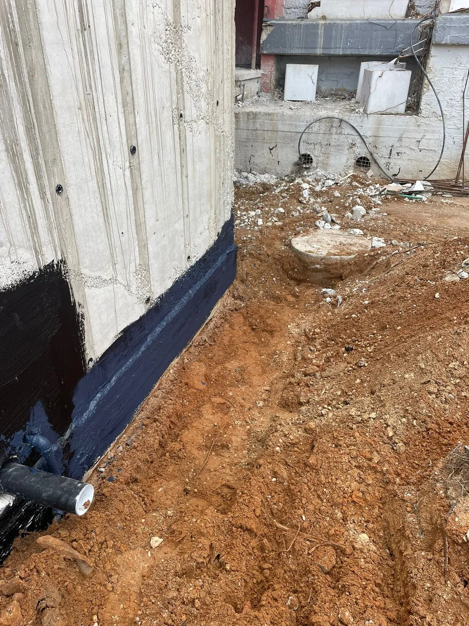 חפירת תעלה לאורך קיר יסוד, איטום ביטומני והנחת קו ניקוז היקפי