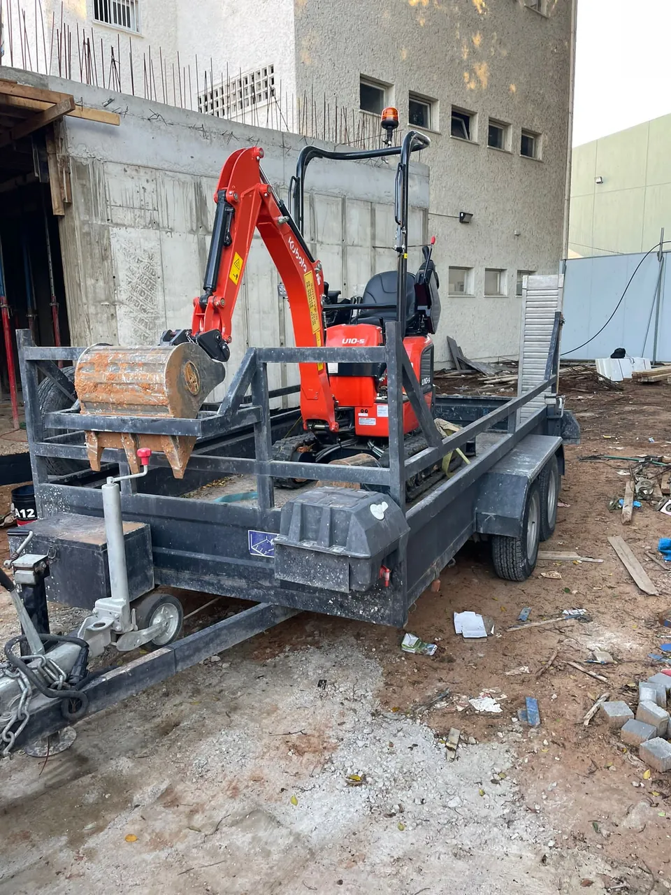מיני מחפרון על גרור בכניסה לאתר עבודה בתוך מבנה