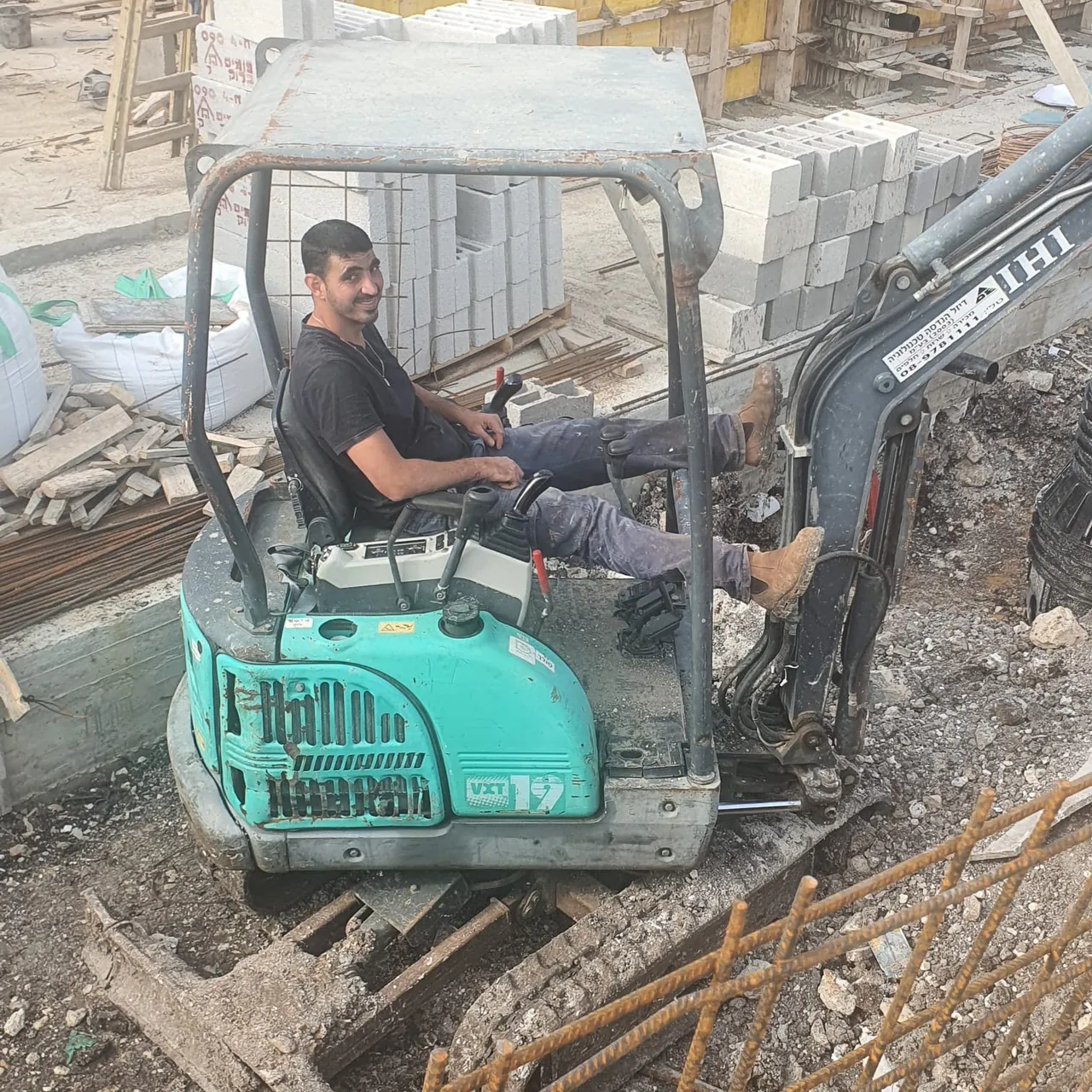 מפעיל מיני מחפרון של אפיקי מרום בעבודה באתר בנייה