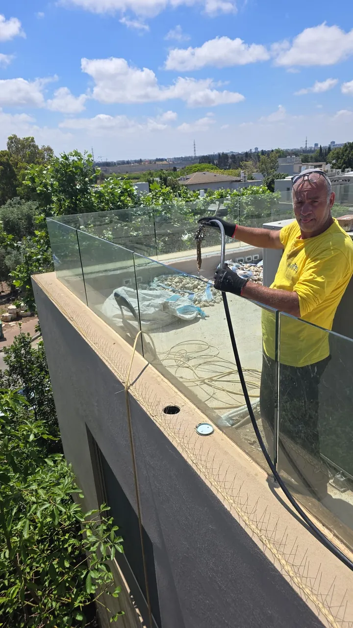 טכנאי משחיל ספירלה לפתיחת סתימה בקו ניקוז של מרפסת