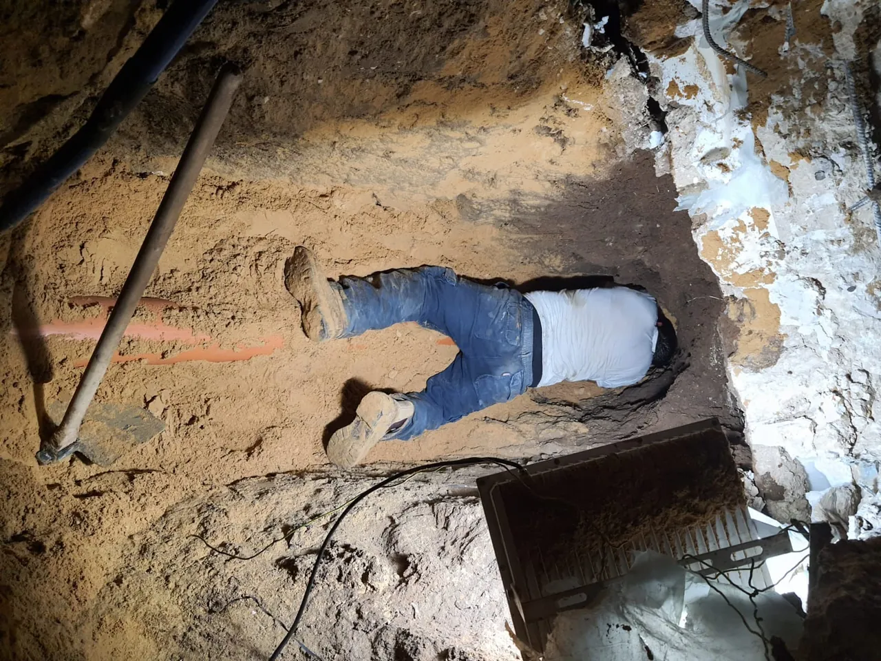 חפירה צרה מתחת לקיר לחשיפת קו צנרת פגוע