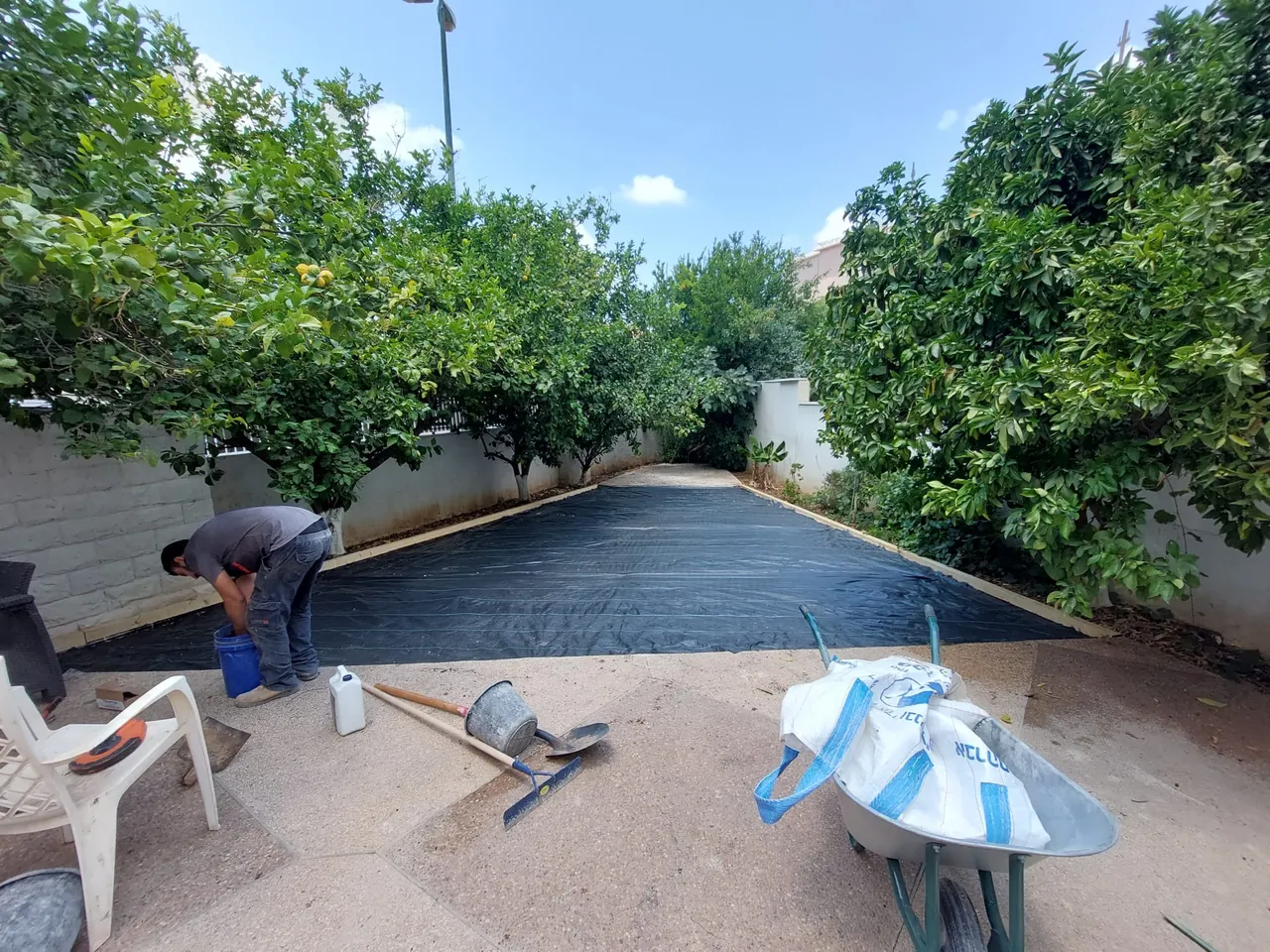 פריסת יריעות איטום בחצר לפני כיסוי וריצוף